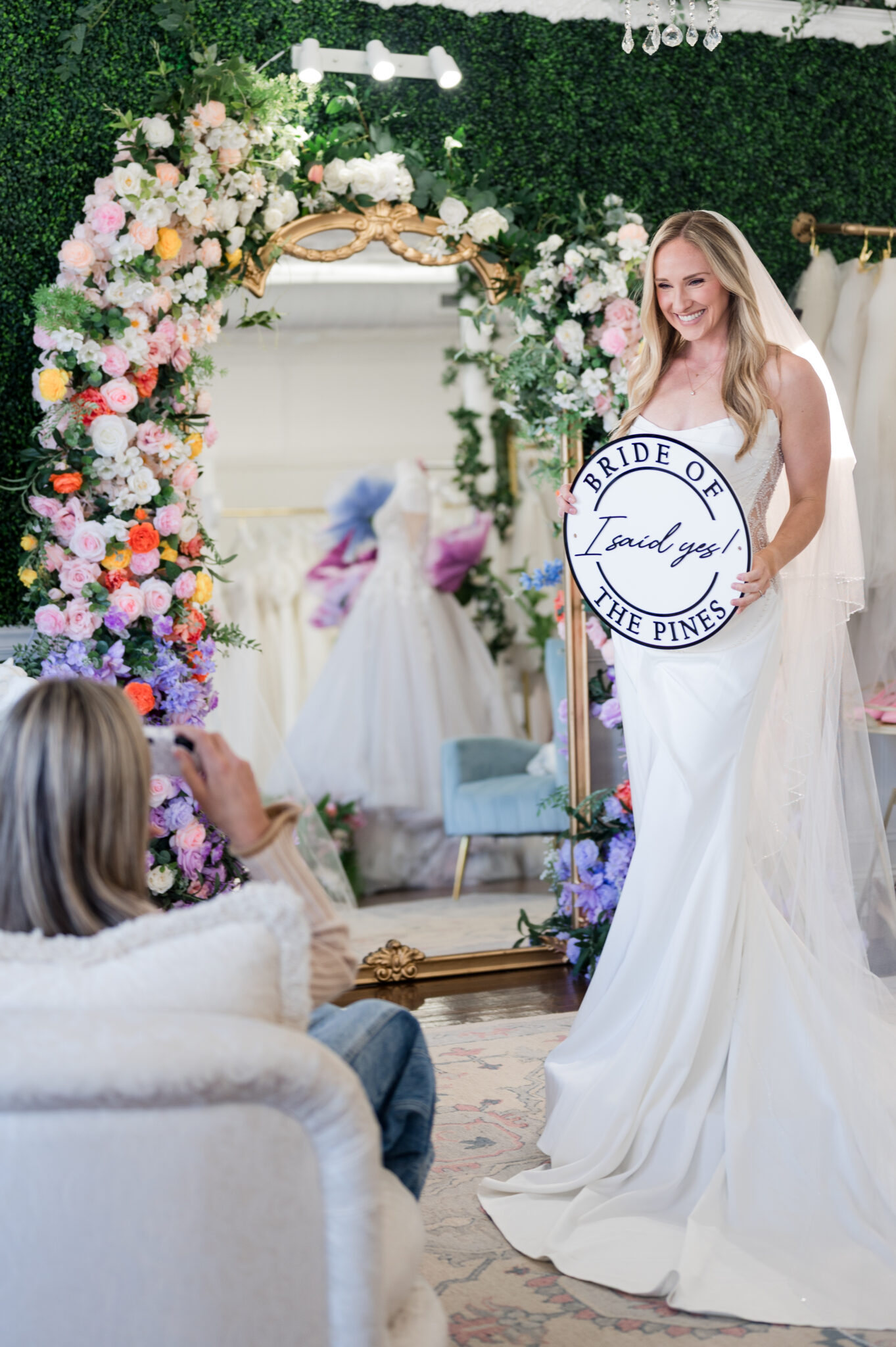 bride holding the I said yes at bride of the pines sign after saying yes to her wedding dress in pinehurst and southern pines nc
